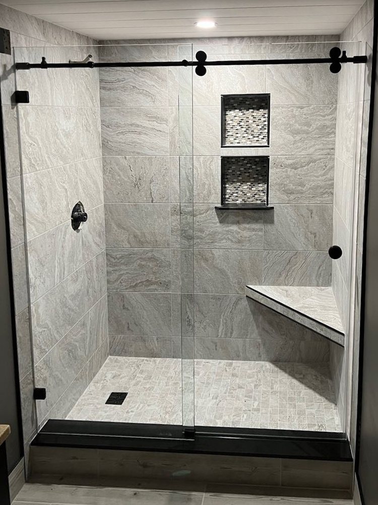 Sliding glass shower door on a matte black track